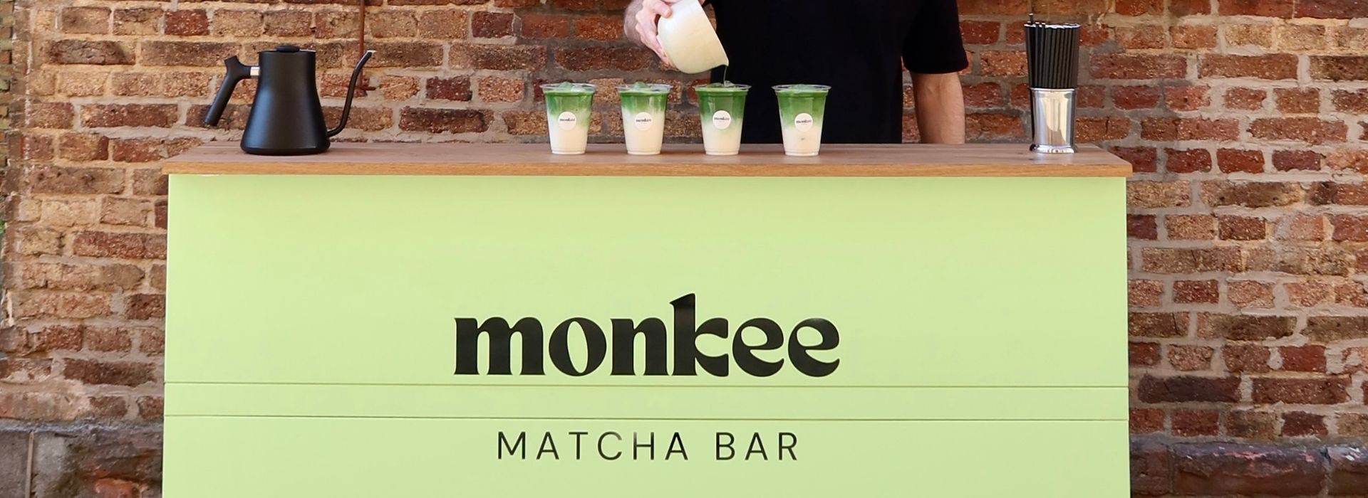 Monkee Matcha Bar Stand bei Event mit Barista beim Eingießen frischer Matcha Lattes